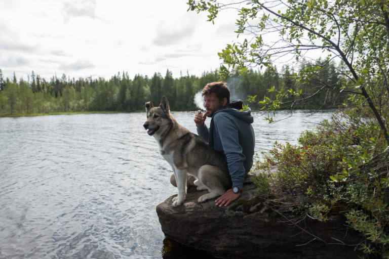 Chien dehors avec son maître en train de fumer