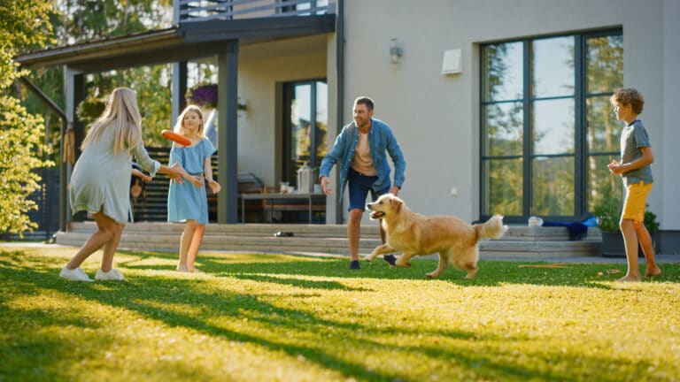 famille qui joue avec son chien dans le jardin