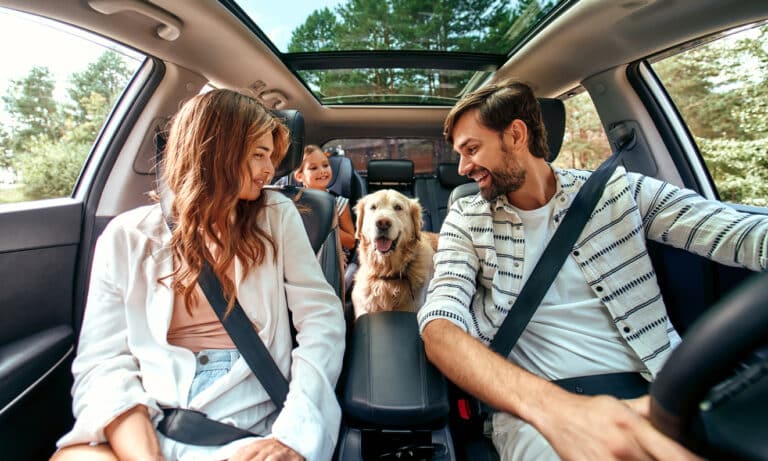 famille avec son chien dans une voiture